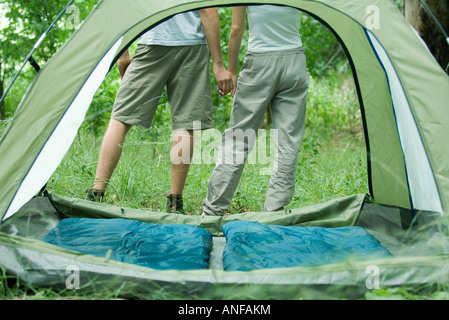 Coppia giovane Holding Hands, visto attraverso la tenda Foto Stock