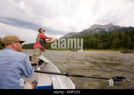 Giovani uomini di Pesca a Mosca Report di Pesca sul Fiume Elk, da un dory mentre guida orologi, Fernie, East Kootenays, British Columbia, Canada. Foto Stock