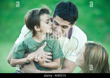 Ragazzo con i genitori, kissing padre sulla guancia Foto Stock