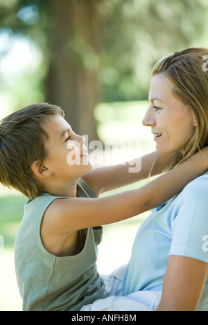 Azienda madre figlio di armi, sia sorridente ad ogni altro, vista laterale Foto Stock