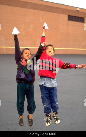 Gli studenti età 11 battenti aeroplani di carta in corrispondenza del recesso durante la scuola estiva. Holland Scuola Minneapolis Minnesota USA Foto Stock