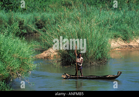 Uomo in un tradizionale canoa di corteccia di andare a pesca su un fiume nella provincia di Zambezia rurale,. Mozambico Foto Stock