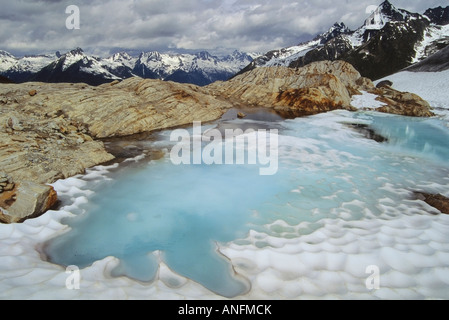 Un piccolo laghetto glaciale ai piedi del ghiacciaio Illicillawaet, il Parco Nazionale di Glacier, British Columbia, Canada. Foto Stock