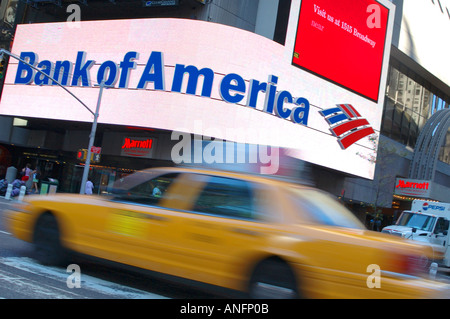 Enorme Bank of America segno con una offuscata passando giallo taxi, Times Square, New York New York Foto Stock