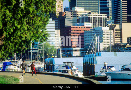 Giovane con i rollerblade intorno a Stanley Park National Historic Site con il centro di Vancouver in background, British Columbia, Canada. Foto Stock