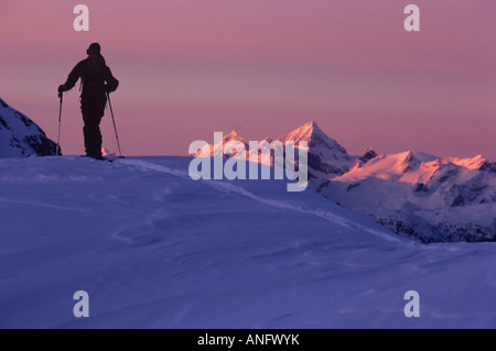 Backcountry rider in alpenglow affacciato su Canadian Rockies, Selkirk Mountains, British Columbia, Canada. Foto Stock