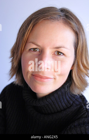 Testa e spalle colpo di professional femmina bianco sorridente in telecamera Foto Stock