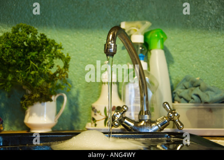 Foto di stock di acqua dal rubinetto da cucina su una griglia sporchi giacente nel lavandino Foto Stock