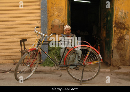 Un egiziano uomo seduto in una stradina nel centro storico della città del Cairo in Egitto Foto Stock