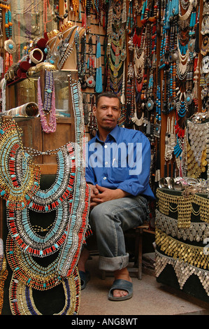 Negoziante seduti in un negozio di souvenir che offre in Khan el-Khalili un grande souk nel centro storico del Cairo islamico Egitto Foto Stock