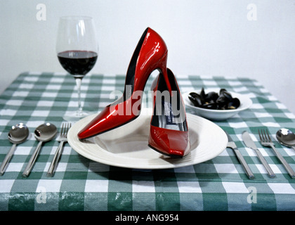 Scarpe vita un paio di rosso tacco alto scarpe su una piastra per cena Foto Stock