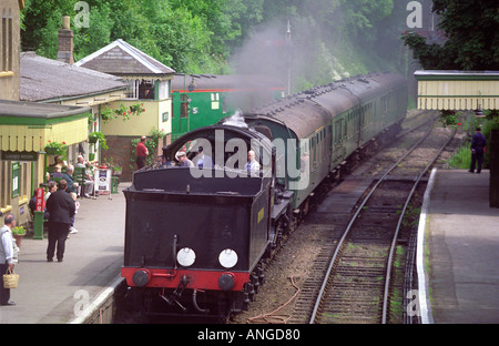 Conserve di treno a vapore che tira in alla stazione Alresford, presentandosi come Ferrovia Meridionale era, sulla linea di crescione metà Hants Railway Regno Unito Foto Stock