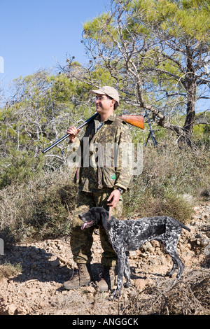 Un cacciatore cipriota primavera migratori uccello Sparatutto con Shotgun; Songbird tiro e caccia nella penisola di Akamas, Pafo, Cipro, Foto Stock