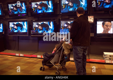 Ai clienti di navigare nel dipartimento di televisione a circuito cittadino negozio di elettronica Foto Stock