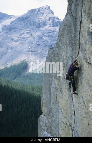 Un giovane uomo crack scalata di un percorso in Ghost River Valley in Alberta, Canada. Foto Stock
