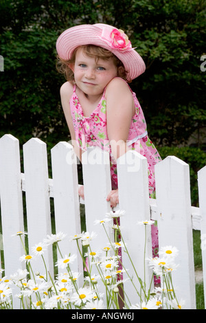 5 anno vecchia ragazza con sundress e hat in piedi di fronte a Picket Fence, Canada. Foto Stock