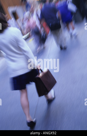 Donna d'affari in gonna e scarpe alte tacco che camminano giù il street porta con sé una valigetta New York City NYC Foto Stock