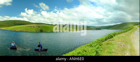 La pesca con la rete utilizzando due coracles sulle sponde di un lago in Galles Foto Stock