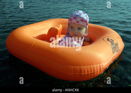 Baby girl orange salvagente anello di gomma Oceano Mare Viaggi turismo vacanze la libertà di svago spensierato in orizzontale Foto Stock