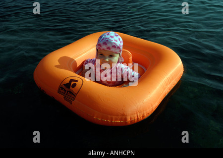 Baby girl orange salvagente anello di gomma Oceano Mare Viaggi turismo vacanze la libertà di svago spensierato in orizzontale Foto Stock