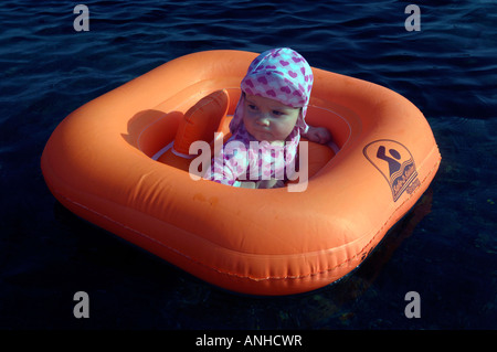 Baby girl orange salvagente anello di gomma Oceano Mare Viaggi turismo vacanze la libertà di svago spensierato in orizzontale Foto Stock