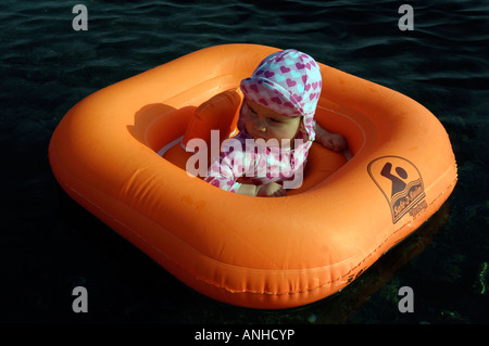 Baby girl orange salvagente anello di gomma Oceano Mare Viaggi turismo vacanze la libertà di svago spensierato in orizzontale Foto Stock