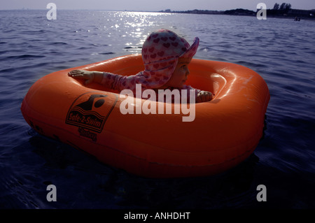 Baby girl orange salvagente anello di gomma Oceano Mare Viaggi turismo vacanze la libertà di svago spensierato in orizzontale Foto Stock