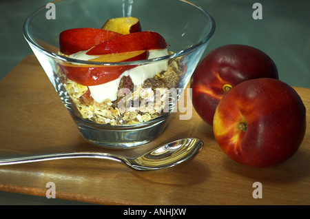 Una ciotola di croccante muesli, yogurt e le nettarine. Foto Stock