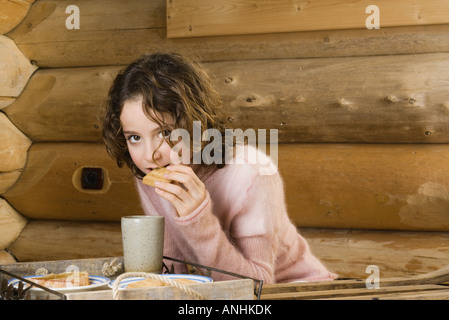 Ragazza con snack, guardando la fotocamera Foto Stock