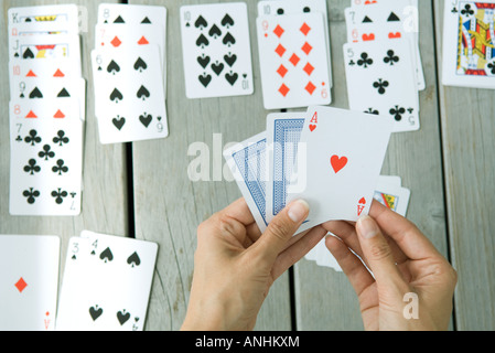 La donna la riproduzione di gioco di carte, vista ritagliata delle mani Foto Stock