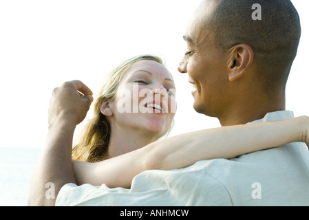 Giovane abbracciando e sorridente ad ogni altro uomo di toccare donna capelli Foto Stock