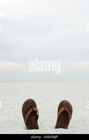 Flipflops semi-sepolto nella sabbia, close-up Foto Stock
