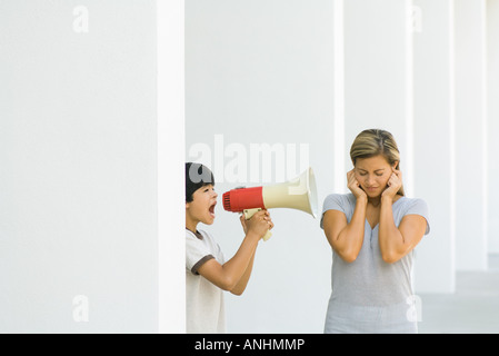 Ragazzo urlando a madre attraverso il megafono Foto Stock