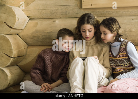 Un ragazzo e una ragazza guardando teen girl video gioco Foto Stock