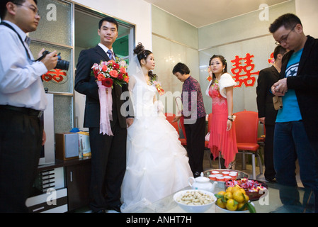 Nozze cinesi, la sposa e lo sposo in piedi, il cibo e le bevande sul tavolo Foto Stock