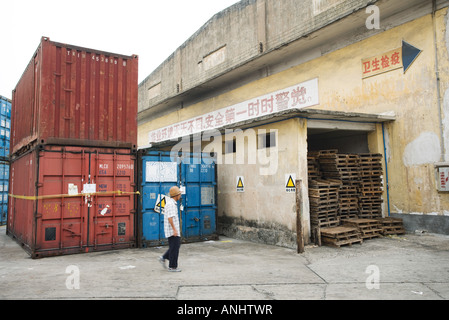 Cina, uomo a camminare attraverso la zona industriale Foto Stock