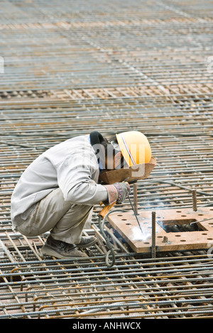 Operaio edile lavora al sito in costruzione Foto Stock