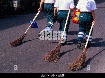 Roma Italia tre operatori sanitari che trasportano le scope in Piazza Navona. Scena di strada, vita quotidiana in Europa Foto Stock