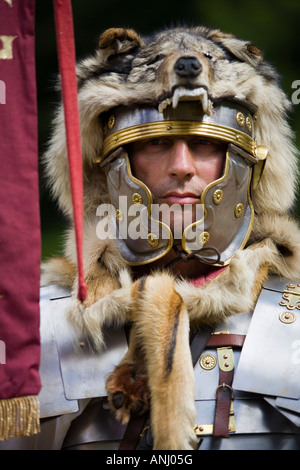 Un reenactor vestito come un centurione romano e tenendo un legionnary standard, Chedworth, Gloucestershire, Regno Unito Foto Stock