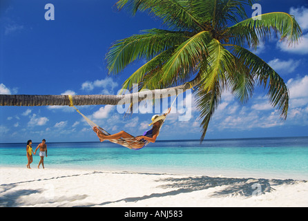 Giovane donna che passa in amaca sulla isola di Fihalhohi delle Maldive Foto Stock