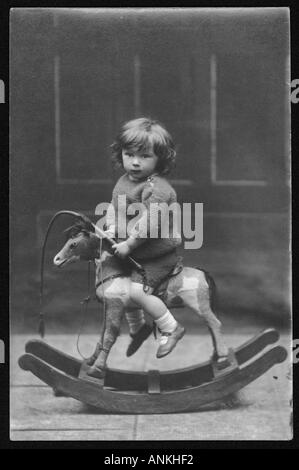 Ragazzo sul cavallo a dondolo Foto Stock