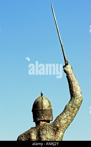 Vista posteriore della statua del guerriero tenendo sollevato di spada al calare della luna a Maldon,Essex, Inghilterra, Regno Unito Foto Stock