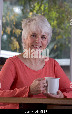 Felice donna senior con la tazza di caffè Foto Stock