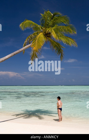 Lavoro imprenditore indossando Bowler cappello sulla spiaggia tropicale idilliaco Foto Stock