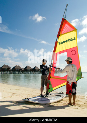 Maldive South Male Atoll Olhuveli Resort watersport una donna con il windsurf lezione sulla spiaggia Foto Stock