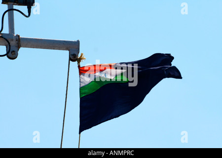 Close up Indian bandiera nazionale che fluttua nel vento su Flagstaff in sullo sfondo di un cielo blu chiaro Foto Stock