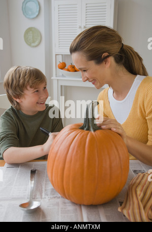 Madre e figlio di decorare la zucca Foto Stock