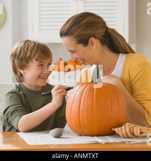 Madre e figlio di decorare la zucca Foto Stock