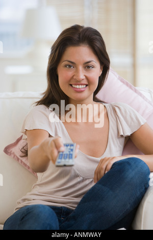 Donna ispanica di guardare la televisione Foto Stock