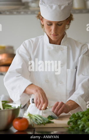 Lo chef femmina tritare verdure Foto Stock